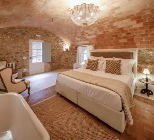 a bedroom with a large bed and a bath tub at Castell de Vallgornera in Girona
