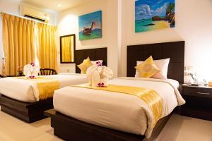 una habitación de hotel con dos camas con animales de peluche. en Q Victory Patong Hotel, en Patong Beach