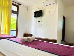 Lake Face Hotel في أنورادابورا: غرفة نوم عليها سرير وفوط