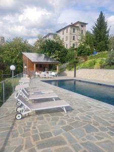 een zwembad met ligstoelen naast een gebouw bij Villa Pavone in Coreglia Antelminelli