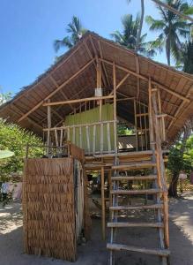 a building with a wooden roof and a ladder at Bice Camp Darocotan in El Nido