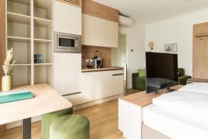 a bedroom with a bed and a desk and a kitchen at Landhaus Bad Gleichenberg in Bad Gleichenberg