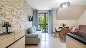 a living room with a couch and a stone wall at Morskie Apartamenty przy plaży PIAMOLA in Krynica Morska