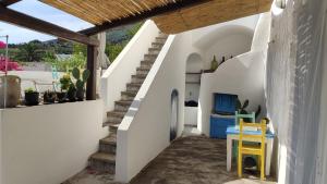 a stairway with a blue table and a yellow chair at La Casa di Nonna Ida in Stromboli