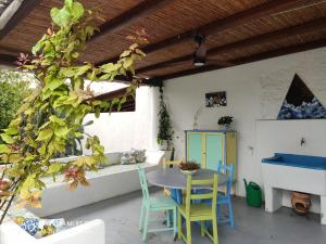 un patio con mesa, sillas y un árbol en La Casa di Nonna Ida en Stromboli