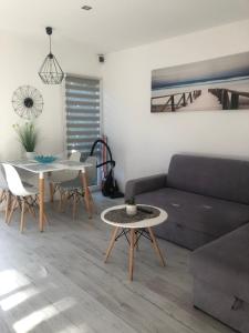 Domek Przy Plaży في ميلنو: غرفة معيشة مع أريكة وطاولة
