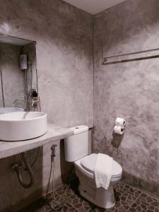 Un baño con un inodoro blanco y un lavabo. en THANSILA Resort, en Ranong