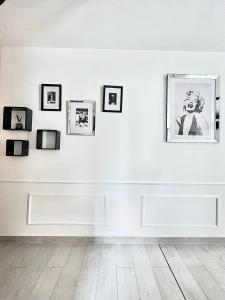 une chambre blanche avec des photos sur un mur dans l'établissement Palais 5min Luxury&Cinema Studio, à Cannes