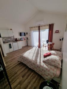 a bedroom with a bed and a wooden floor at Escapade Beaujolaise - Studio in Taponas