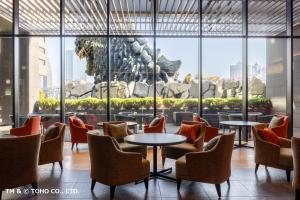 a lobby with tables and chairs and a lion statue at Hotel Gracery Shinjuku in Tokyo