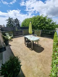 a patio with a table and a yellow umbrella at Escapade Beaujolaise - Studio in Taponas