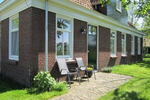 a patio with two chairs and a table on a house at Aan de Dijk in Edam