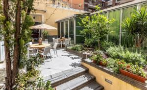 an outdoor patio with a table and chairs and plants at HOSTEL PORTICI in Portici
