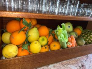 a shelf filled with oranges and other fruits and vegetables at HOTEL al FARO ,SPIAGGIA LA CINTA ,SAN TEODORO in San Teodoro