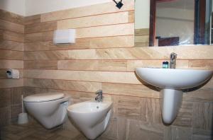 a bathroom with a sink and a toilet and a mirror at HOTEL Al FARO , SPIAGGIA LA CINTA ,SAN TEODORO in San Teodoro