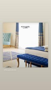 a bedroom with two beds and a blue chair at Florya Novi Hotel in Istanbul