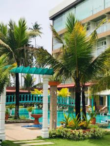 a resort with palm trees and a swimming pool at Aryana Queen Beach Resort in Wadduwa