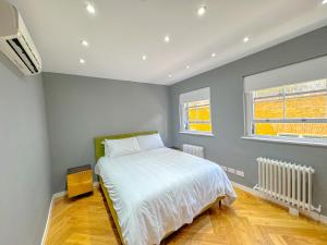 a bedroom with a bed and two windows at Mayfair Residences in London