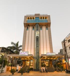 奧蘭加巴德的住宿－Hotel Krishna Inn, Aurangabad，一座建筑,前面的人坐在