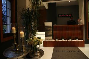 a man in a suit standing in a lobby with a table with candles at Biz Cevahir Hotel Sultanahmet in Istanbul