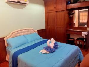 um bicho de peluche está deitado numa cama em Tanyaporn House em Haad Rin