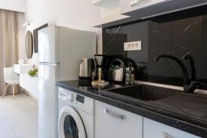 a kitchen with a sink and a washing machine at SkyBlue Horizon Studio 2 in Tsilivi