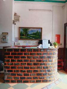 un comptoir en briques avec une peinture sur le mur dans l'établissement Kiến An Hotel Cần Thơ, à Cần Thơ