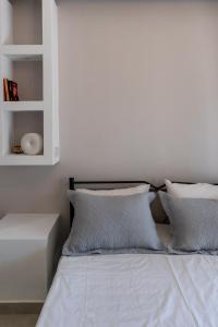 a bed with white sheets and pillows in a bedroom at SkyBlue Horizon Studio 2 in Tsilivi