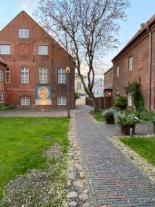a cobblestone street in front of a brick building at Wohlfühlen in historischem Haus in Brake