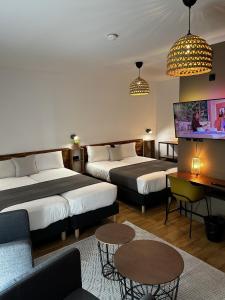 pokój hotelowy z dwoma łóżkami i telewizorem w obiekcie Hôtel Lodge In Paris 13 w Paryżu