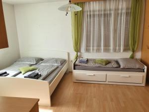 2 Betten in einem Schlafzimmer mit grünen Vorhängen in der Unterkunft Ferienwohnung 123 in Fohnsdorf