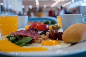a plate of food with eggs and fruit on a table at Hotel Don Juan Tossa in Tossa de Mar