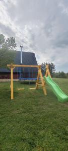 a playground with a green slide in the grass at Ranč Crna stina in Livno