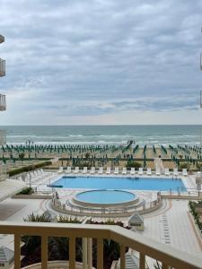 - une vue sur la piscine et la plage dans l'établissement RESIDENCE PANFILO - WALTERIGATO Apartments SOLO PER FAMIGLIE, à Lido di Jesolo