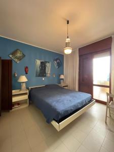 ein Schlafzimmer mit einem Bett und einer blauen Wand in der Unterkunft RESIDENCE PANFILO - WALTERIGATO Apartments SOLO PER FAMIGLIE in Lido di Jesolo