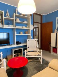 - un salon avec une table rouge et une chaise dans l'établissement RESIDENCE PANFILO - WALTERIGATO Apartments SOLO PER FAMIGLIE, à Lido di Jesolo