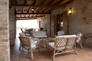 un patio con sillas, una mesa y una mesa con sillas en Villa Anna - Homelike Villas, en Montone