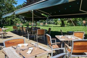 a group of tables and chairs under an umbrella at Domaine Les Lanternes in Saint-Cyr-au-Mont-dʼOr