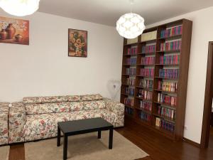 a living room with a couch and a book shelf with books at A.U.M House in Bucharest