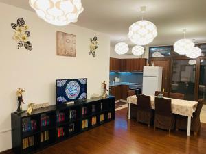 a living room with a dining table and a kitchen at A.U.M House in Bucharest
