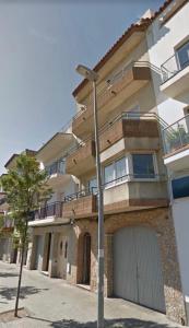 a apartment building with a garage and a street light at Apartamento tranquilo en Roses centro cerca de la playa Costa brava in Roses