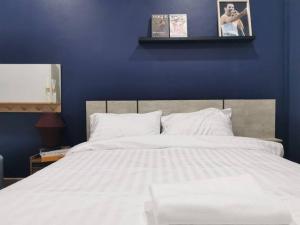 a bedroom with a large white bed with a blue wall at RB01 Chatuchak, Netflix, SpeedNet, Bts,mrt, 10Pax in Bangkok