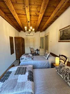 2 letti in una camera con soffitti in legno di B&B Domus iulii a Cividale del Friuli