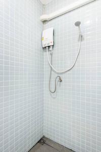 W łazience z białymi kafelkami znajduje się prysznic. w obiekcie RB01 Chatuchak, Netflix, SpeedNet, Bts,mrt, 10Pax w mieście Bangkok