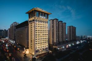西安市にあるvoco Xi'an Qindu Legend, an IHG Hotelの時計塔がそびえる高層ビル