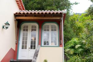 een voordeur van een huis met bomen bij Casa Da Piedade in São Vicente