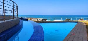 een zwembad met de oceaan op de achtergrond bij Whale Rock 9 - Sleeps 6 - with Inverter - 30m from the beach - 70m from the Margate Pier - 180 Degree sea view in Margate