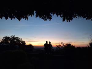 a couple standing in front of the sunset at Borgo Fastelli in Sarteano