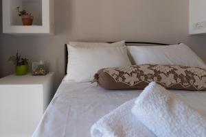 a white bed with white pillows and a blanket on it at SkyBlue Horizon Studio 1 in Tsilivi