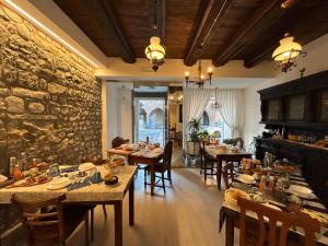a dining room with tables and chairs and a stone wall at Domus Iulii in Cividale del Friuli
